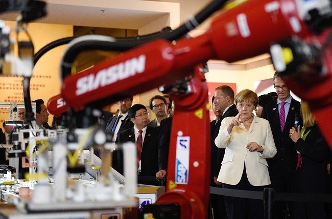 German Chancellor Angela Merkel (R) watches a presentation on industry 4.0 at the Industry Museum in Shenyang, China, 14 June 2016. (EPA Photo)