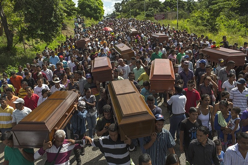 Villagers carry remains of 9 slain men from a fishing family to the cemetery in Cariaco, Venezuela, Nov. 13, 2016. 5 law enforcement officers were charged with killing these men, who were widely thought to have belonged to a piracy gang. (AP Photo)