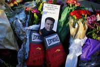Boxing gloves and a message sit among flowers at a makeshift memorial to Muhammad Ali at the Muhammad Ali Center, Saturday, June 4, 2016, in Louisville, Ky. (AP Photo)