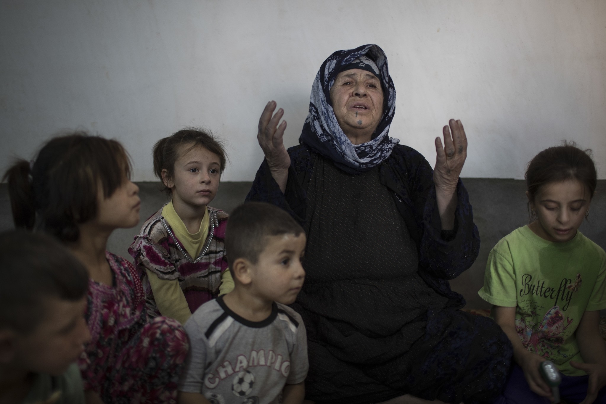 Husna Abbas sits with her grandchildren inside her home in the Yahyawa camp for internally displaced Turkmen on the outskirts of Kirkuk, Iraq, Sunday, Oct. 30, 2016. (AP Photo)