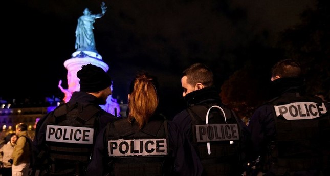 French police officers in service stand guard as their colleagues protest over mounting attacks on officers during a rally at Place de la Republique in Paris on Oct. 19.