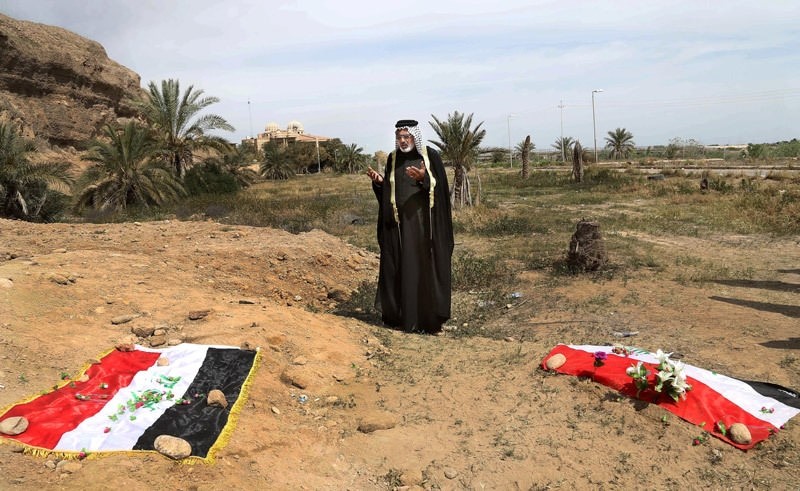 In this April 3, 2015 file photo, an Iraqi man prays for his slain relative, at the site of a mass grave, believed to contain the bodies of Iraqi soldiers killed by Daesh  AP Photo