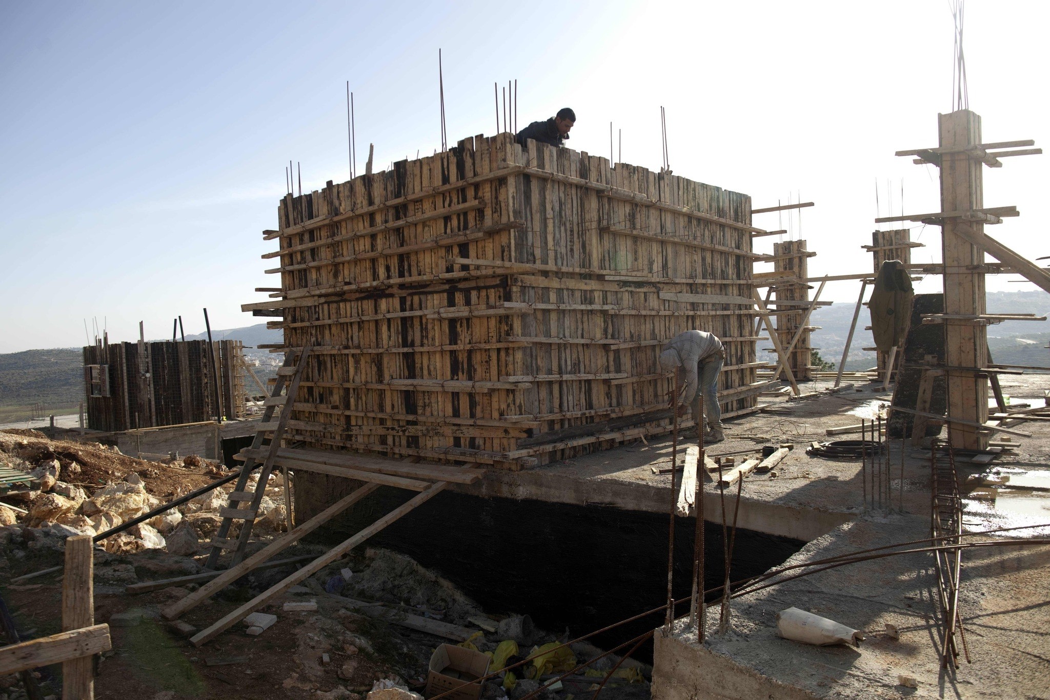 This file photo taken on February 22, 2012 shows Palestinian workers constructing new houses in the Jewish settlement of Shilo in the West Bank. (AFP Photo)