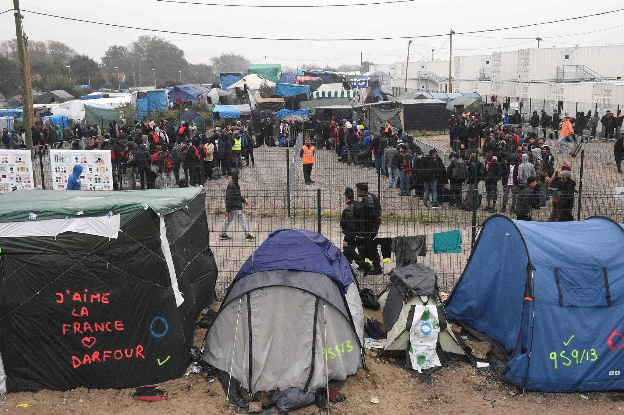 Migrants queue outside a hangar where they were sorted into groups and put on buses headed for shelters across France, as part of the full evacuation of the Calais ,Jungle, camp, in Calais, northern France, on Oct. 24.
