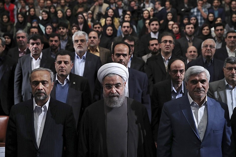 Iranian President Hassan Rouhani, center, listens to the national anthem at the start of a ceremony marking Student Day at Tehran University. Dec. 6, 2016. (AP Photo)
