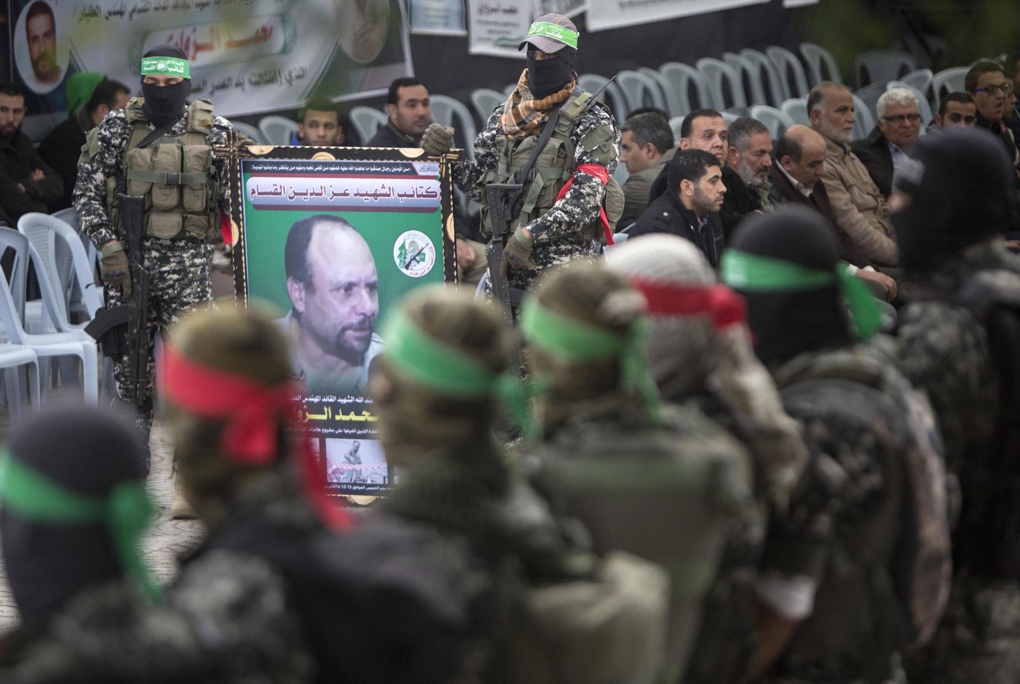 Members of the Ezzedine al-Qassam Brigades hold a banner bearing a portrait of one of their leaders, Mohamed Zaouari. (AFP Photo)
