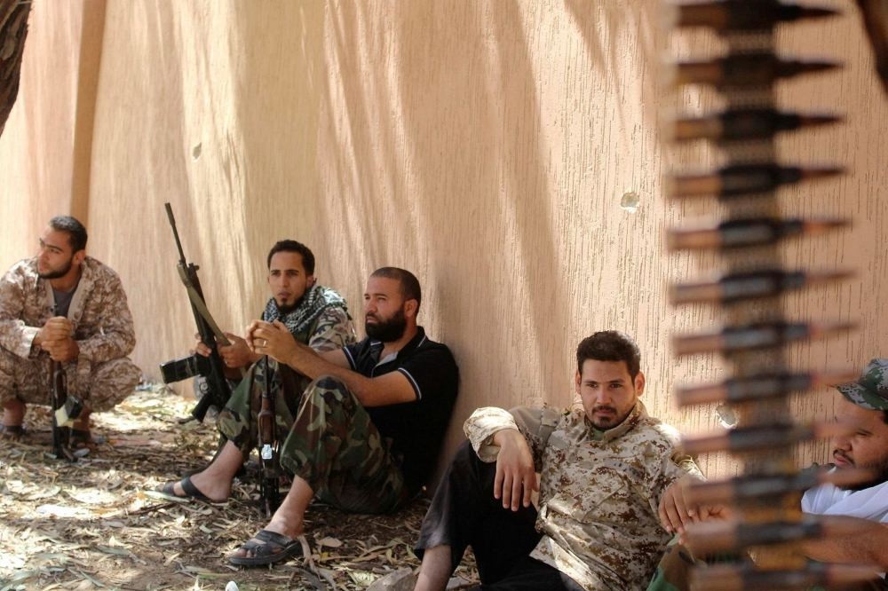Fighters from forces aligned with Libya's new unity government rest after clearing the Zaafran area in Sirte.