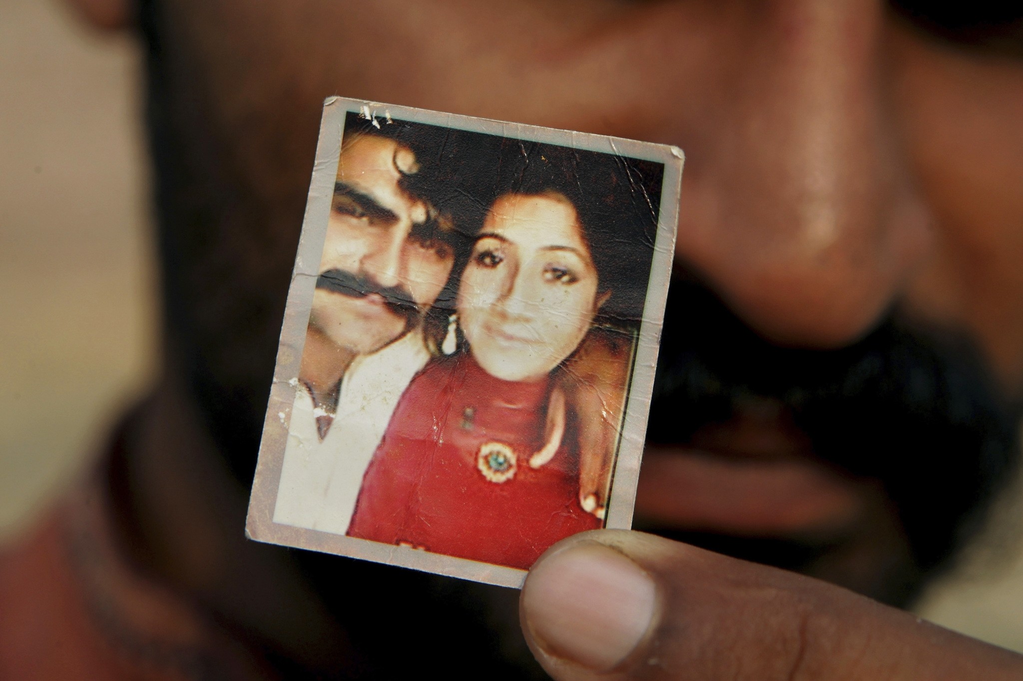 In this June 18, 2016 photo, Mohammed Tofeeq shows a picture with his wife Muqadas Tofeeq, who local police say was killed by her mother, in Butrawala village on the outskirts of Gujranwala, Pakistan. (AP Photo)