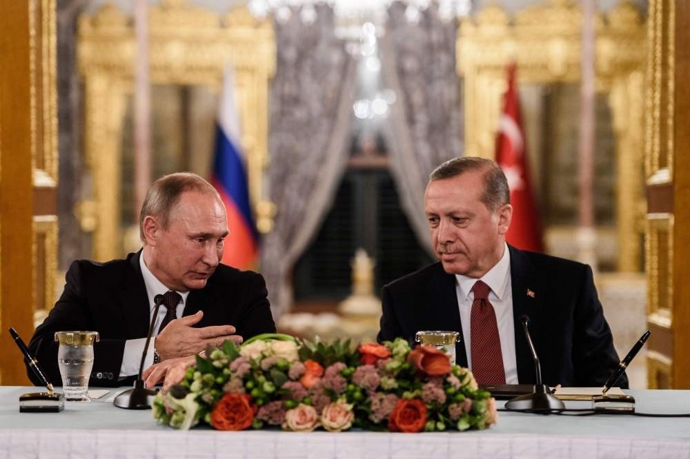 Russian President Vladimir Putin speaking to President Recep Tayyip Erdogan as they attend a press conference in Istanbul.