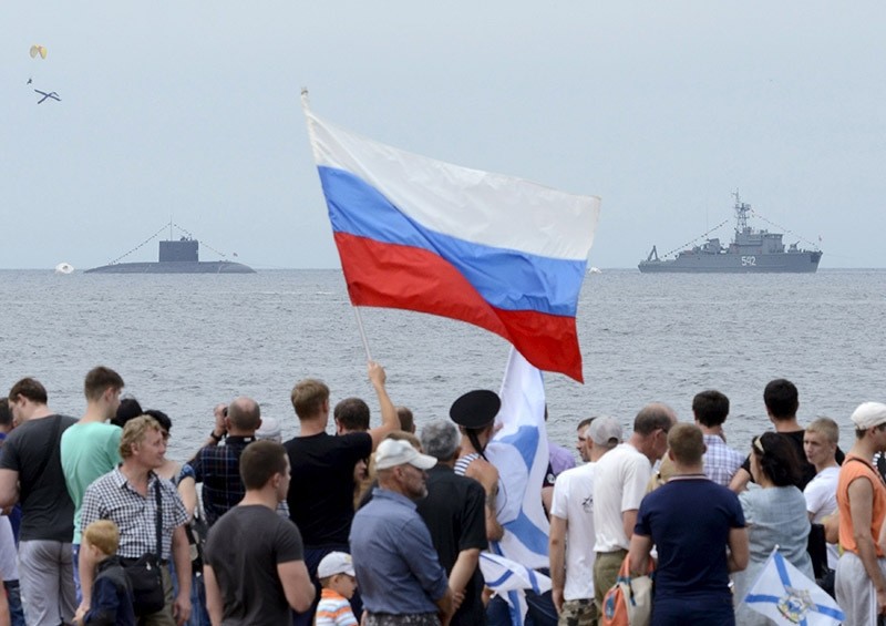 People gather to watch celebrations for Navy Day, with a Russian warship and a submarine seen in the background. July 2015. (Reuters Photo)