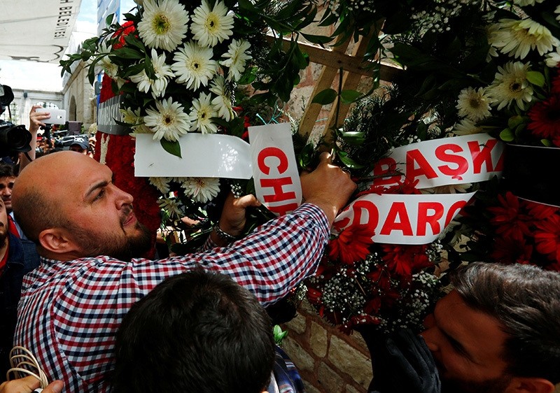 A mourner brings down a wreath from CHP's Ku0131lu0131u00e7darou011flu during a funeral ceremony for the police officers who were killed in Tuesday's car bomb attack on a police bus, in Istanbul, Turkey, June 8, 2016. (Reuters Photo)