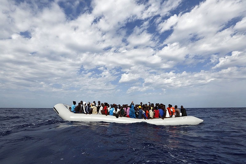 Refugees on a rubber raft waiting to board the 'Phoenix', a ship belonging to the Migrant Offshore Aid Station (MOAS), off the island of Lampedusa, Italy, 04 October 2014 (EPA) 