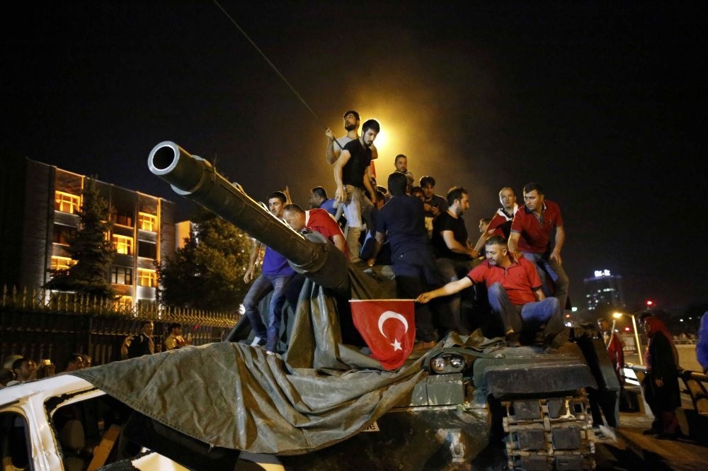 People stand on a Turkish army tank in Ankara, Turkey July 16, 2016.