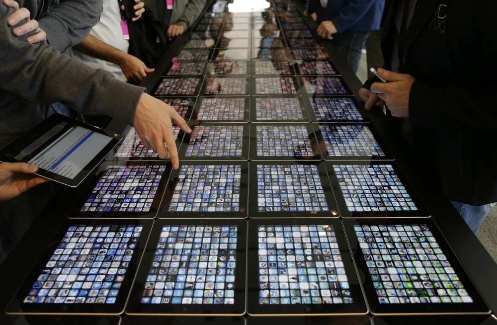 Developers look over new apps displayed on iPads at the Apple Worldwide Developers Conference in San Francisco.