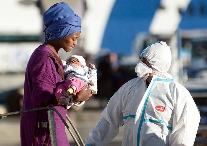 A woman holds a child after disembarking from the Italian Navy ship Borsini in the Sicilian harbour of Palermo, southern Italy, 20 July, 2016. (Reuters Photo)