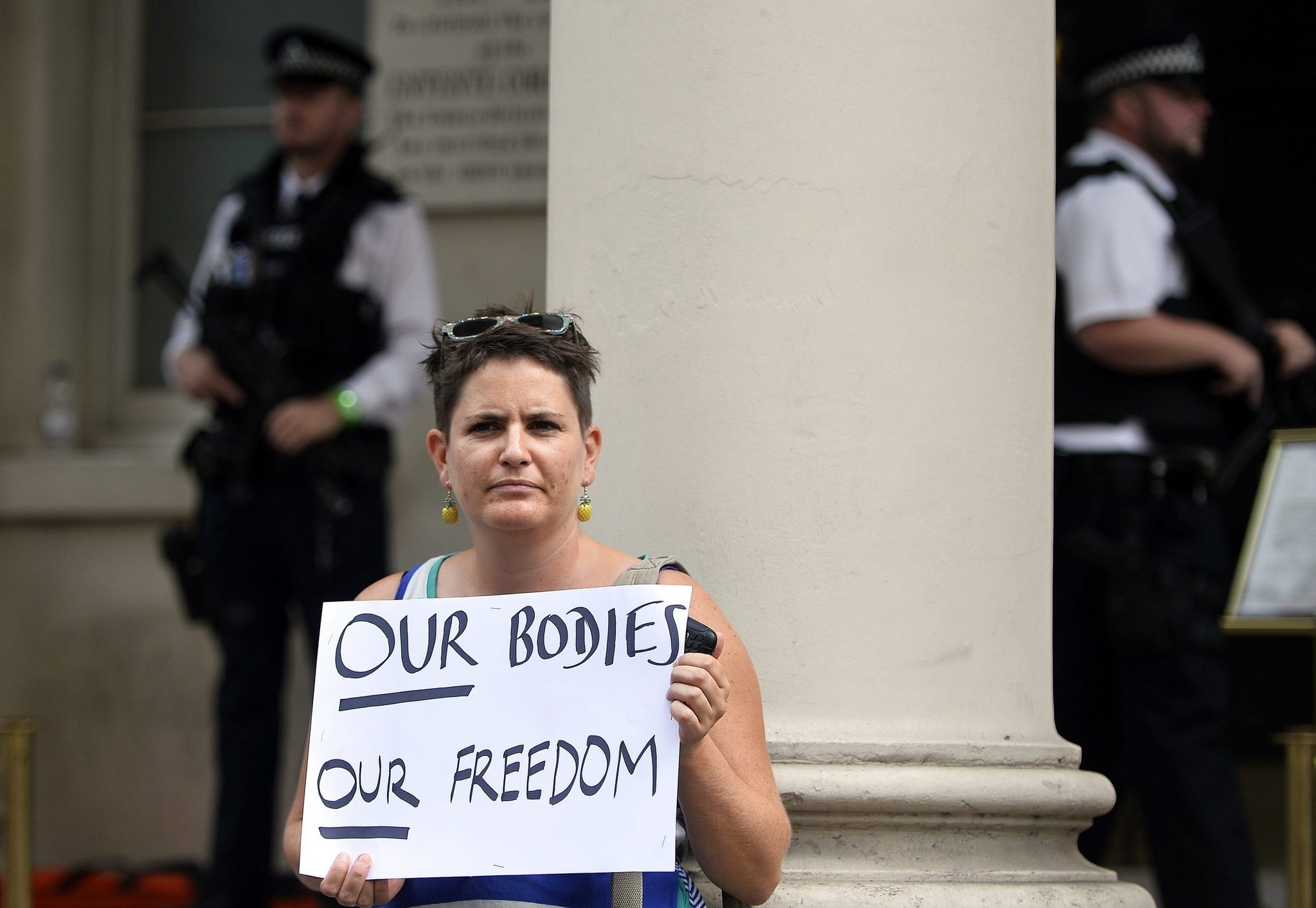 A woman holds a placard during a 'Wear what you want beach party' protest outside of the French Embassy in London, Britain, 25 August 2016. (EPA Photo)