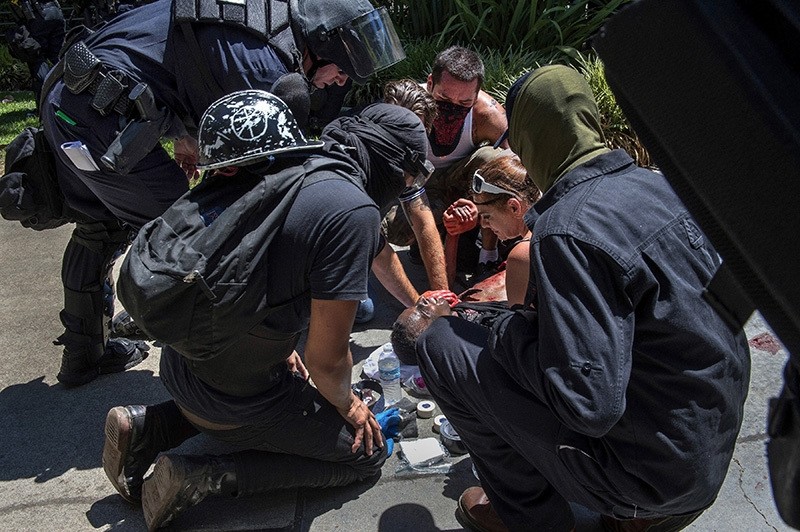 A victim is attended after he was stabbed during a rally at the State Capitol in Sacramento, Calif., on Sunday, June 26, 2016. (AP Photo)