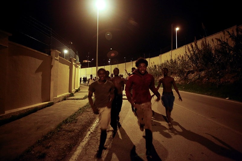 African migrants run on a road after crossing the border fence between Morocco and Spain's north African enclave of Ceuta, December 9, 2016. (Reuters Photo)