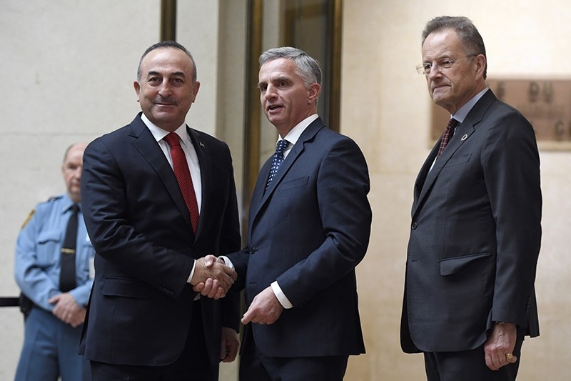 Turkish FM Mevlu00fct Cavuu015fou011flu, left, shakes hands with Swiss FM Didier Burkhalter, center, before the Conference on Cyprus at the European headquarters of the United Nations in Geneva, Switzerland, Thursday Jan. 12, 2017. (AP Photo)