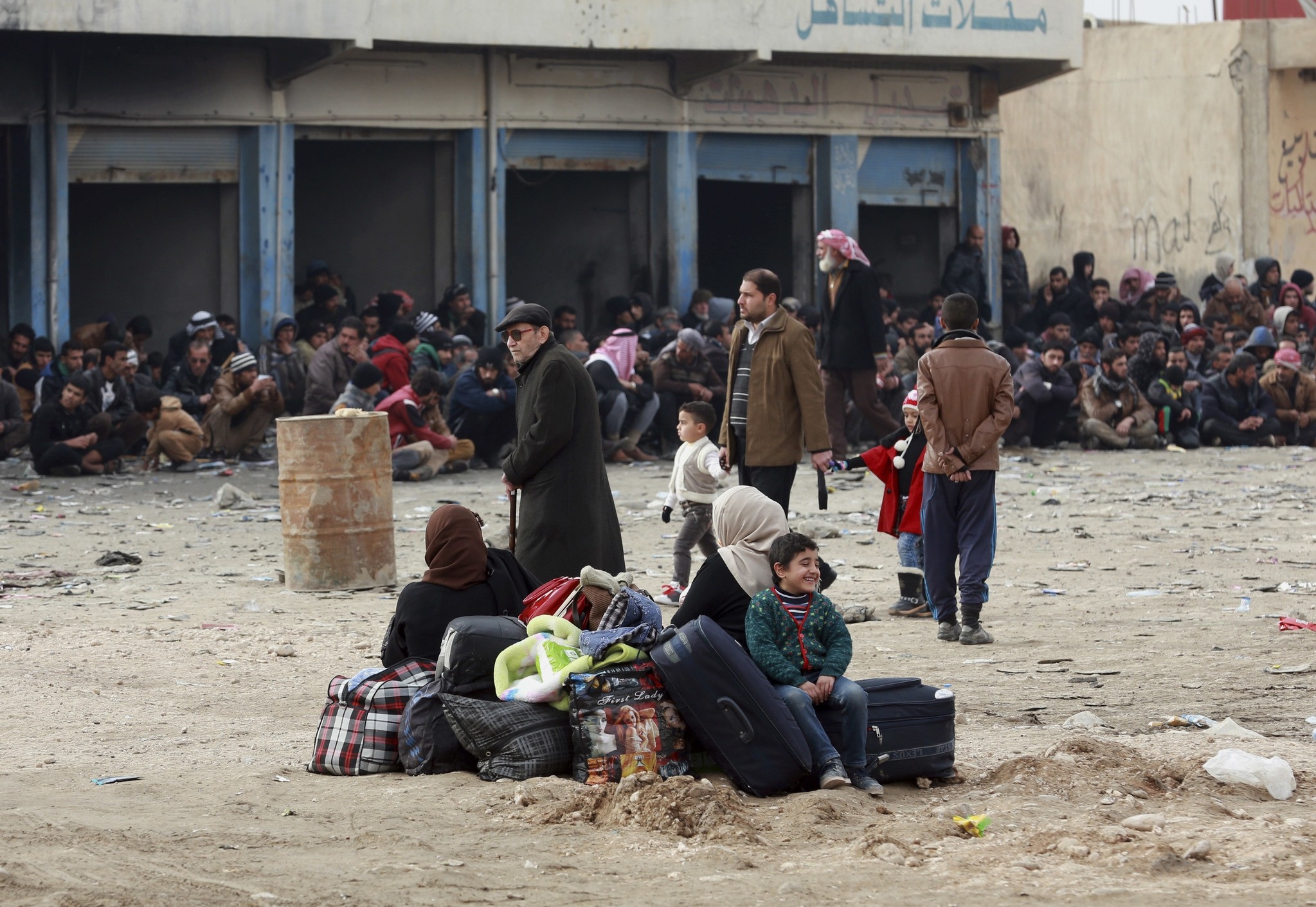 Iraqis waiting at the gathering point to be taken for a camp for internally displaced people, in Bartella, Dec 31, 2016. (AP Photo)