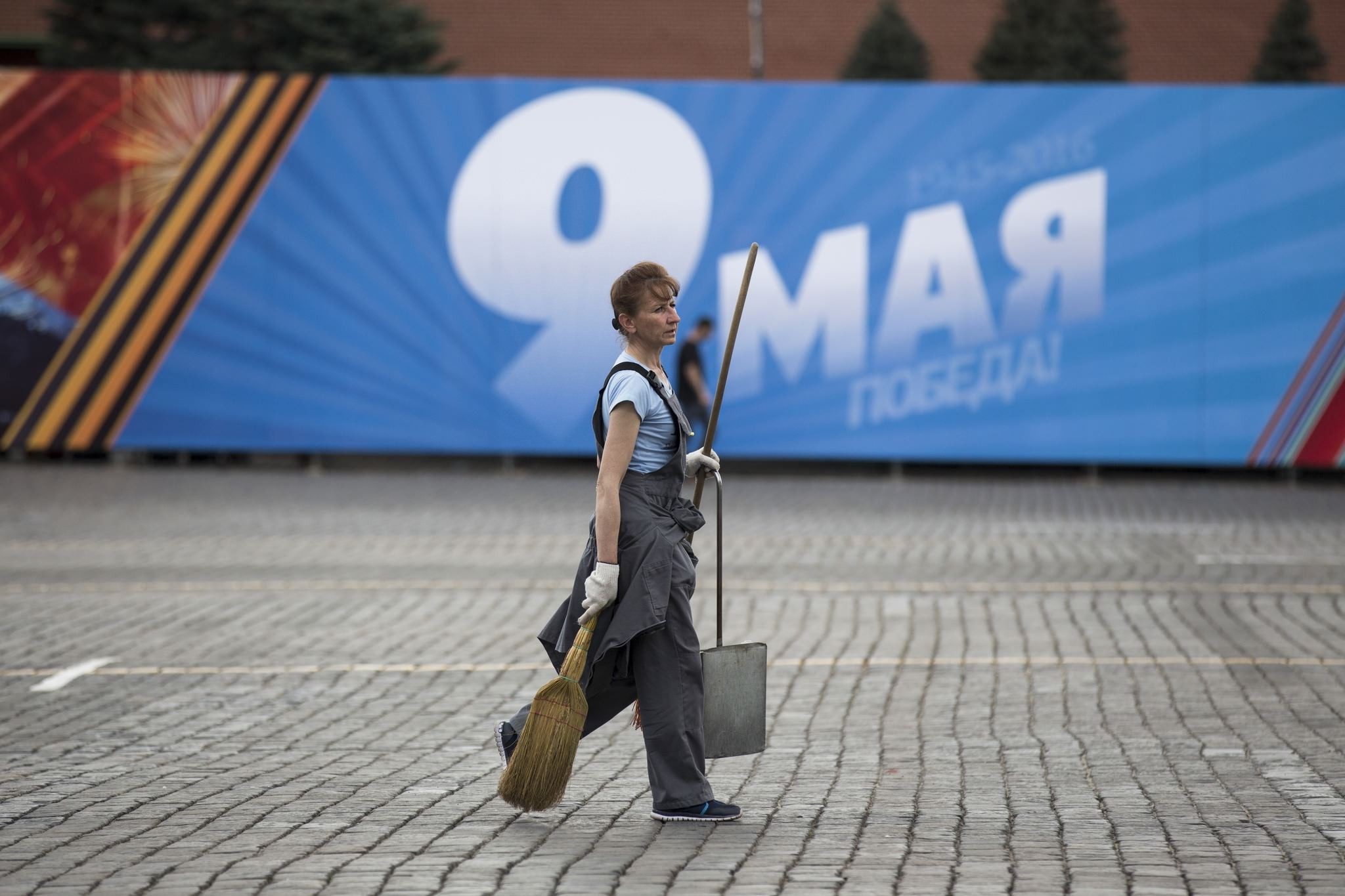 A worker walks past a poster reading ,May 9 Victory, installed for Victory Day celebrations in Red Square in Moscow, Russia, Friday, May 6, 2016 (AP Photo)