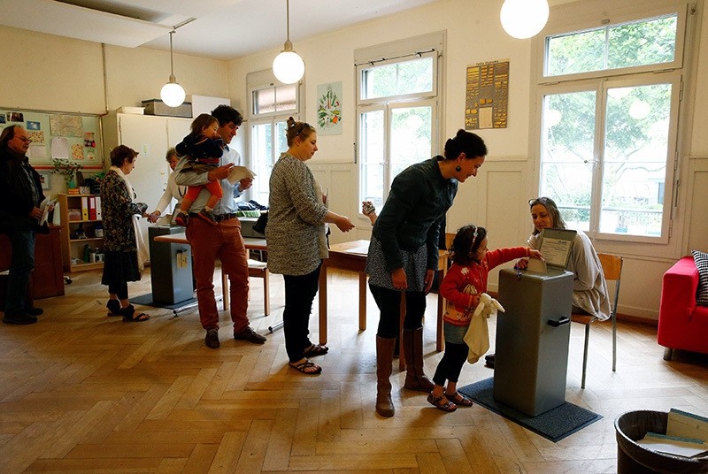 People cast their ballots during a vote on whether to give every adult citizen a basic guaranteed monthly income of 2,500 Swiss francs ($2,560), in a school in Bern, Switzerland. (Reuters Photo)