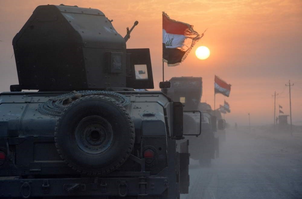 Pro-government forces drive in military vehicles in Iraq's eastern Salaheddin province, south of Hawijah, on Oct. 10, 2016.
