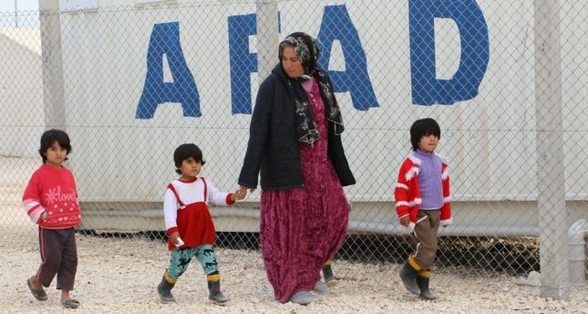  A Syrian refugee woman walks with children at a refugee camp in u015eanlu0131urfa. Women and children make up three quarters of the refugee population according to UNHCR.