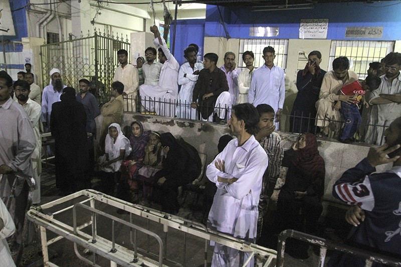 People gather outside an emergency ward of a local hospital after hearing news of a bomb blast at a shrine, in Karachi, Pakistan, Saturday, Nov. 12, 2016. (AP Photo)
