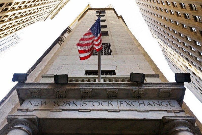 In this file photo, the American flag flies above the Wall Street entrance to the New York Stock Exchange.  AP Photo