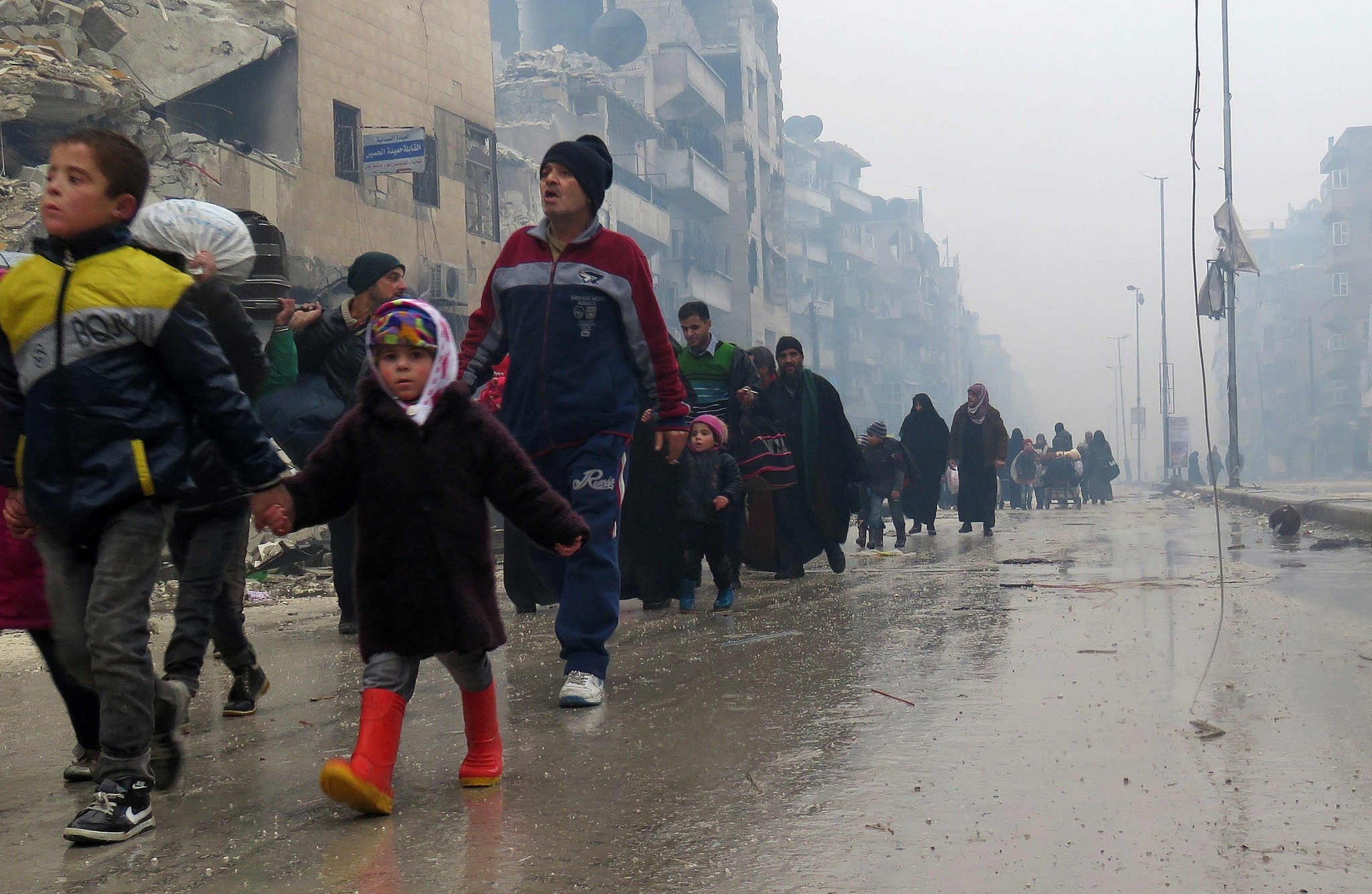 Syrian residents, fleeing violence in the restive Bustan al-Qasr neighbourhood, arrive in Aleppo's Fardos neighbourhood on Dec. 13.