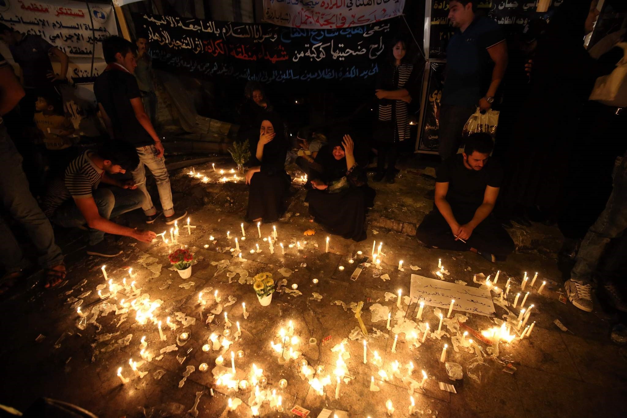 Iraqis light candles on July 5, 2016 at the site of a suicide car bomb attack which took place early on July 3 in Baghdad's Karrada neighbourhood killing at least 213 people and wounding more than 200. (AFP Photo)