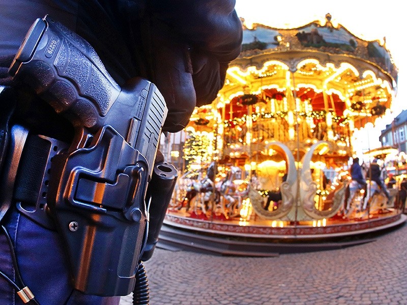 A German police officer stands next to a merry-go-round in the Christmas market in Frankfurt, Germany, Tuesday, Dec. 20, 2016 (AP Photo)