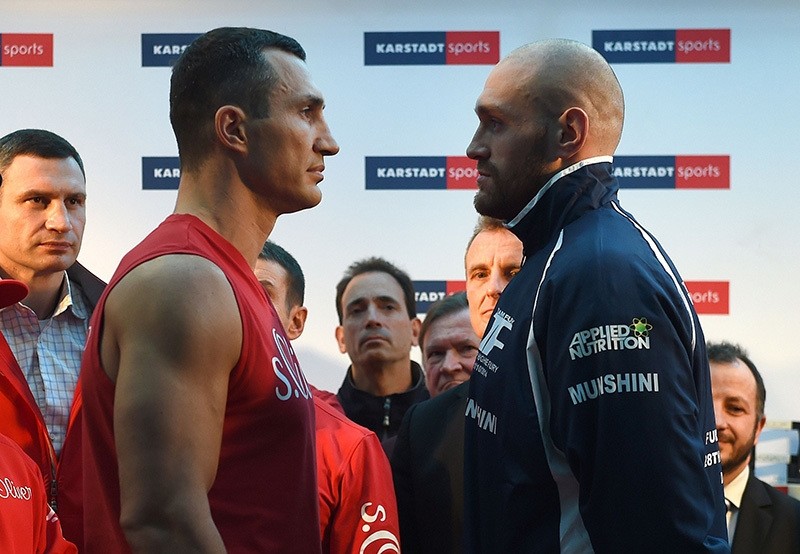 This file photo taken on November 27, 2015 shows Ukrainian Heavyweight World Champion Wladimir Klitschko (2nd L) and his challenger Britain's Tyson Fury (R) posing for a face-off during an official weigh-in in Essen, Germany. (AFP Photo)
