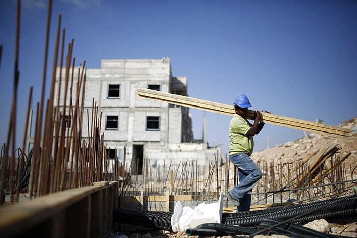 A labourer works on a construction site in Pisgat Zeev, an urban settlement in an area Israel annexed to Jerusalem after capturing it in the 1967 Middle East war August 12, 2013. (Reuters Photo)