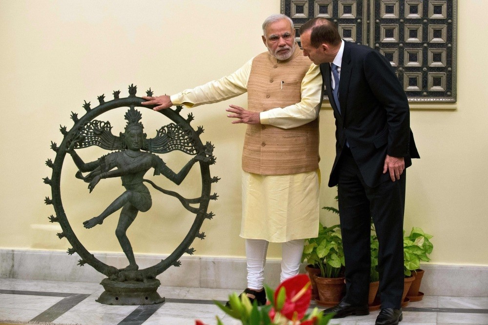 Indian Prime Minister Narendra Modi (L) and former Australian Prime Minister Tony Abbott talk alongside a statue of the Dancing Shiva ahead of a meeting in New Delhi.
