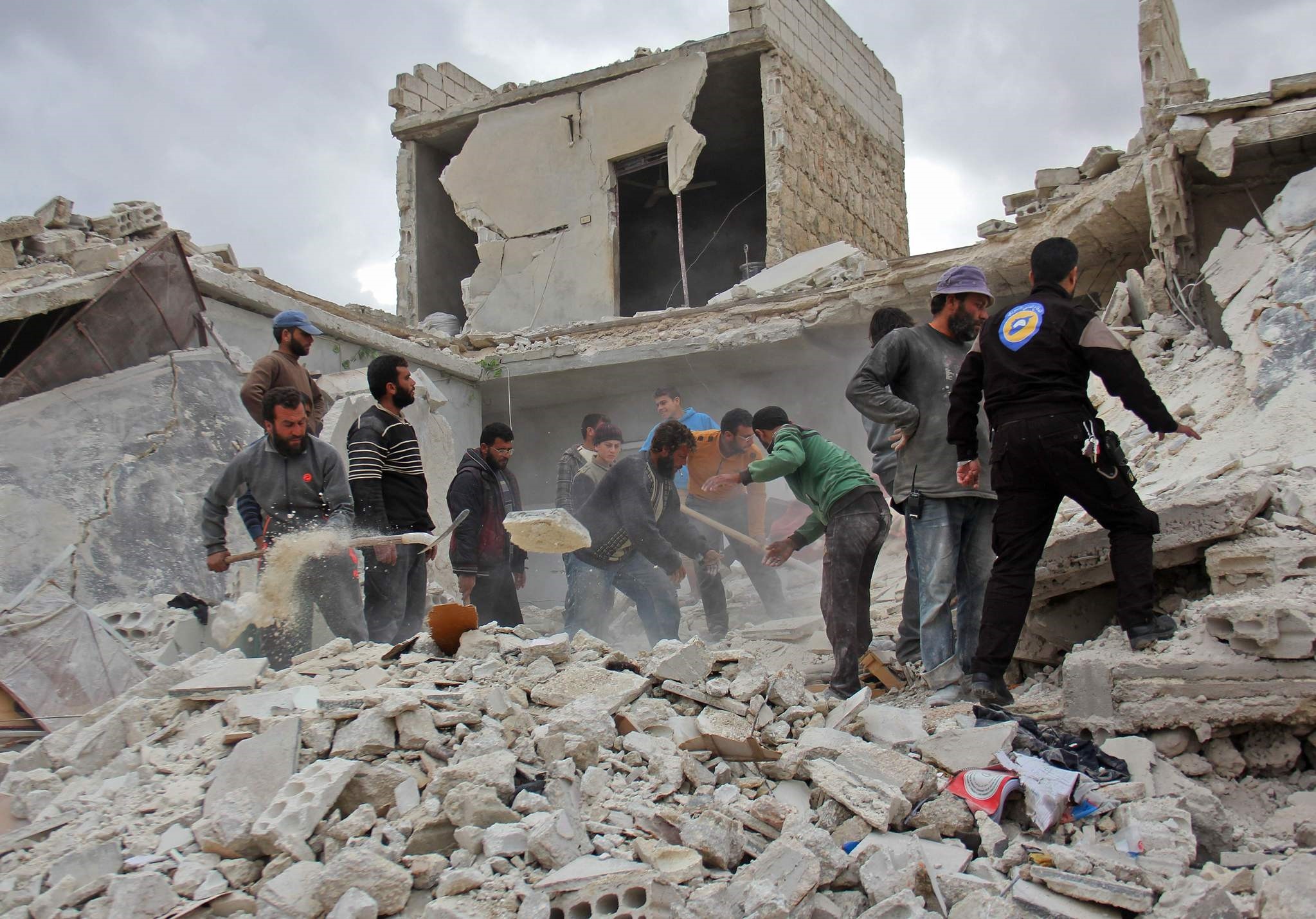 Rescuers and civilians inspect a destroyed building in the Syrian village following air strikes by Syrian and Russian warplanes on November 16, 2016. (AFP Photo)