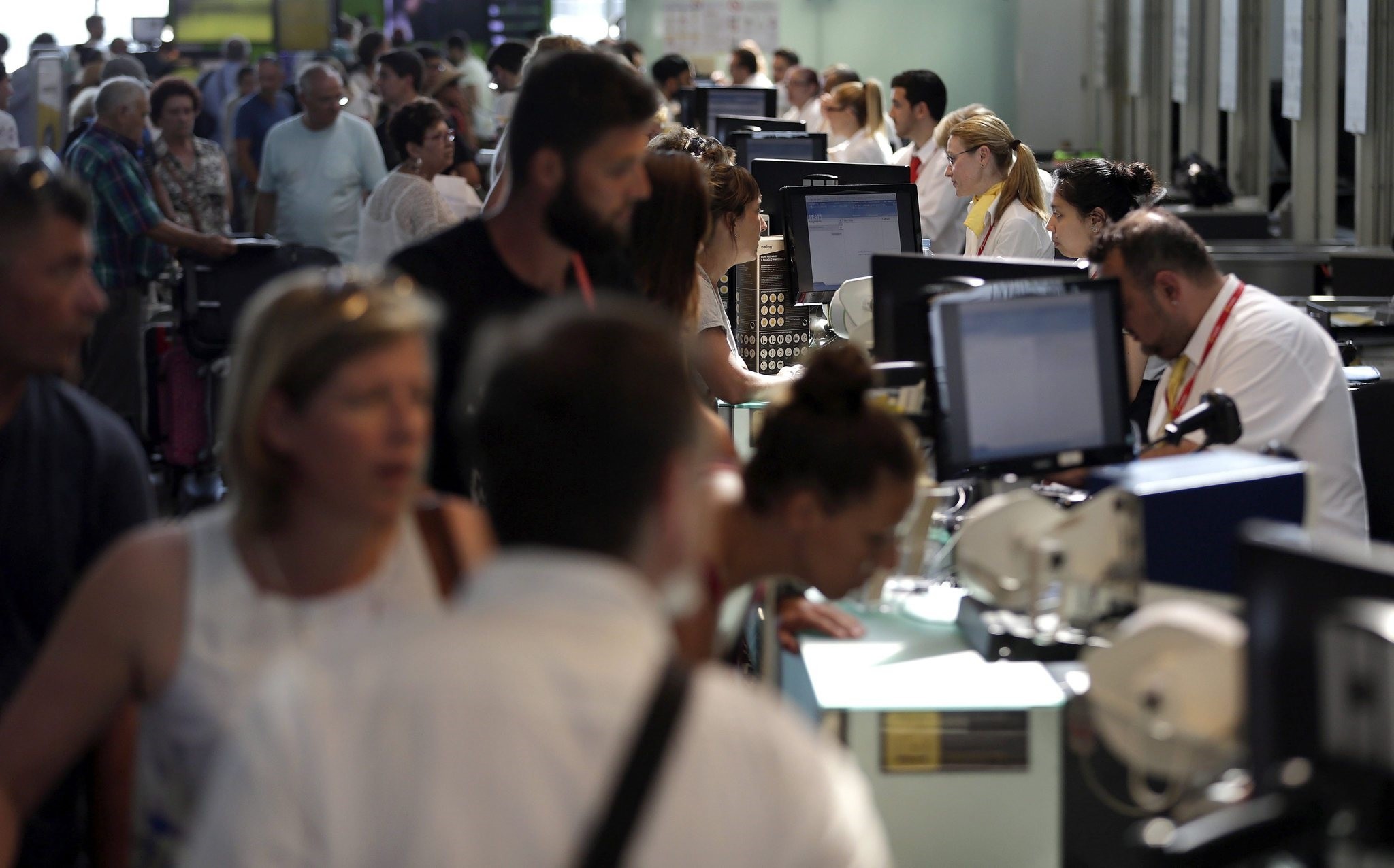Spanish airline Vueling's staff (R) attend travellers at Barcelona's El Prat airport, in Barcelona, northeastern Spain, 02 July 2016. (EPA Photo)