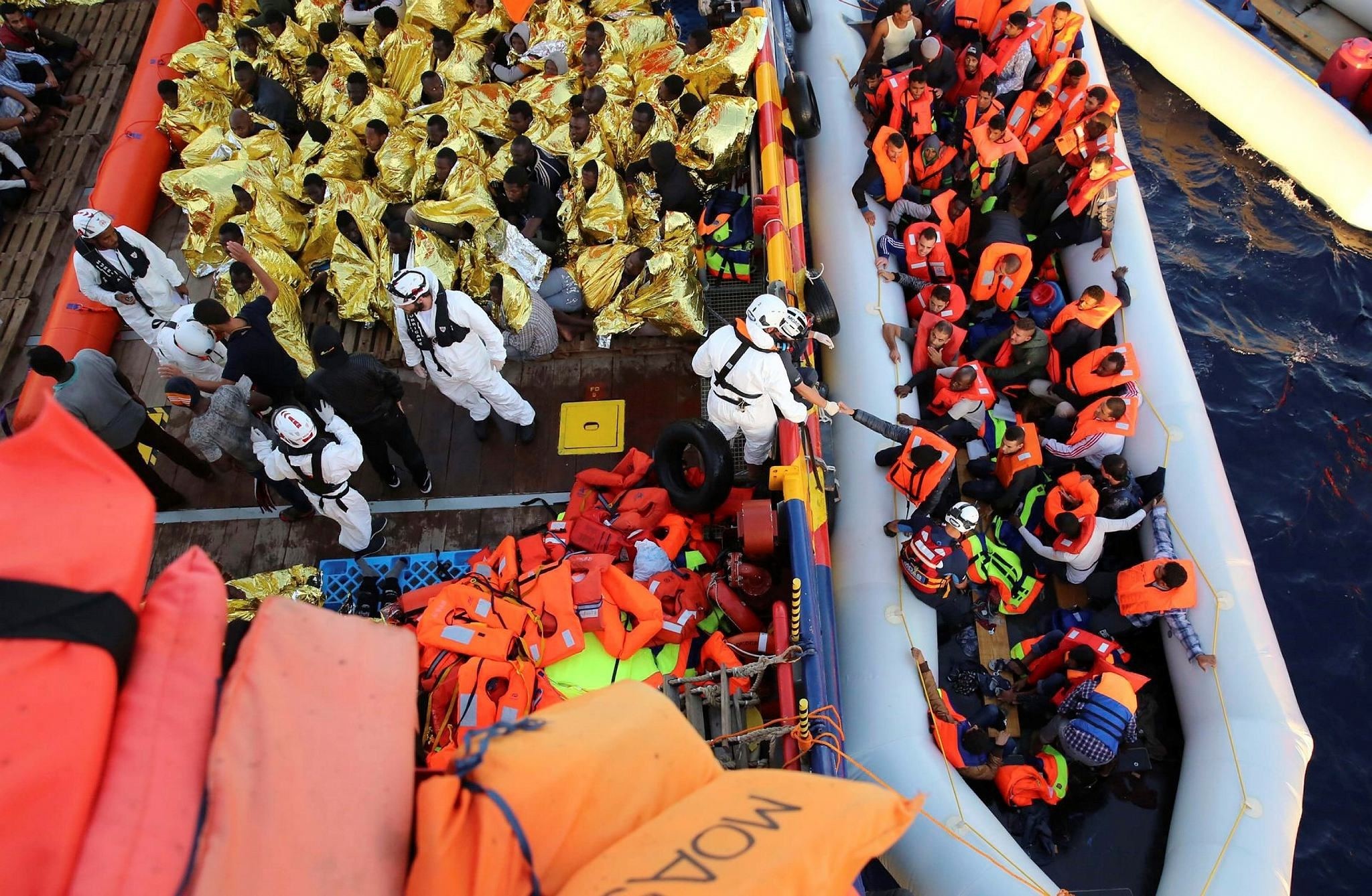 Migrants cover themselves with emergency blankets after being rescued by the vessel Responder. (AP Photo)