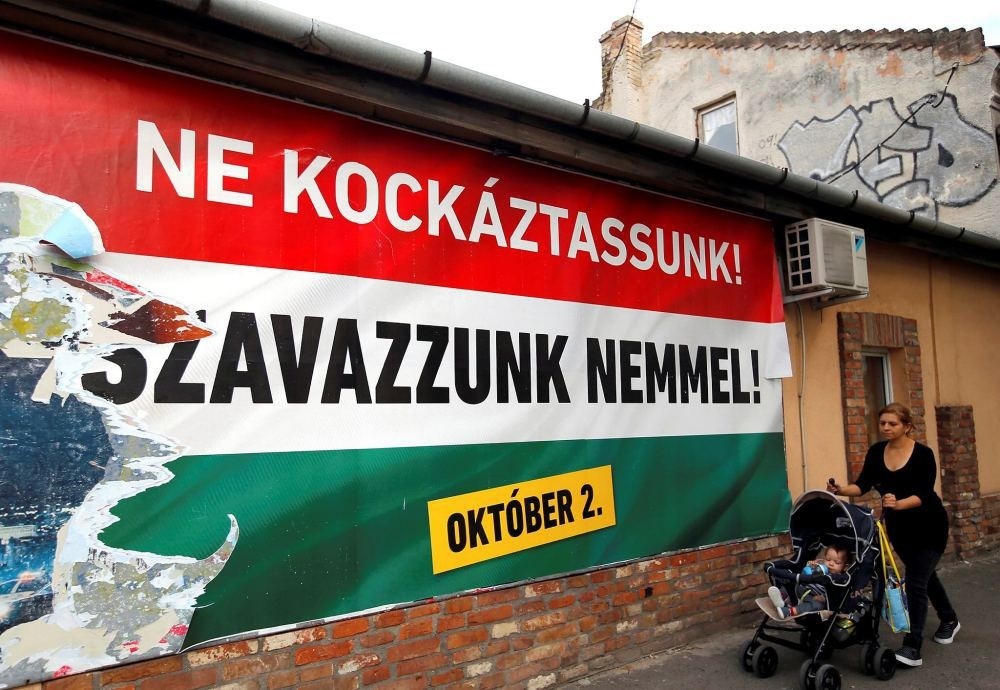 A woman pushes a stroller with her child in front of the Hungarian governmentu2019s poster in Budapest, Hungary, Sept. 28. The poster reads: u201cWe should not take a risk, vote no (to refugees).u201d  (REUTERS Photo)