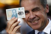 Governor of the Bank of England Mark Carney poses with a new polymer five pound note, at Whitecross Street Market, to promote the launch of the new bank note, in London, on September 13, 2016. (AFP Photo)