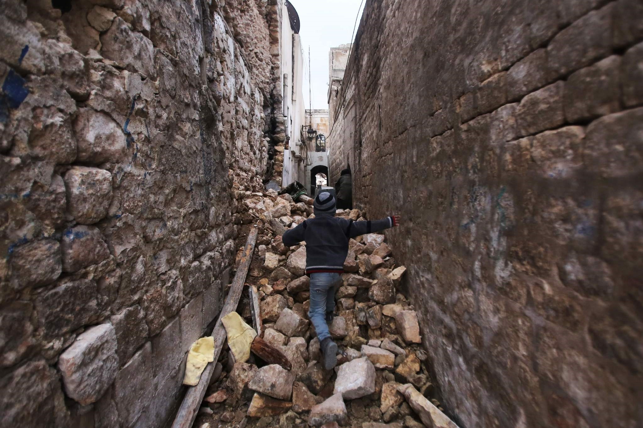 A Syrian boy makeing his way through the rubble of destroyed buildings as he heads to his house in Aleppo's Dahret Awad neighbourhood on Dec. 17, 2016.