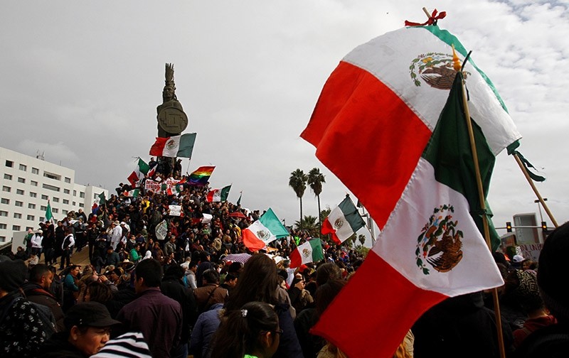 Demonstrators hold Mexico's flags and posters during a protest against a fuel price hike in Tijuana, Baja California state, Mexico January 22, 2017 (Reuters Photo)