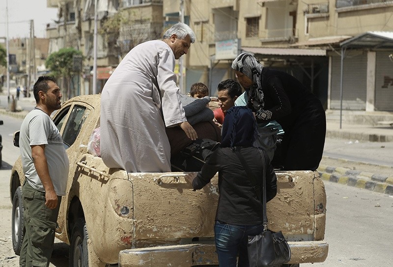 Syrian civilians prepare to flee the northeastern city of Hasakeh during ongoing fighting between YPG and Syrian regime forces on August 22, 2016. (AFP Photo)