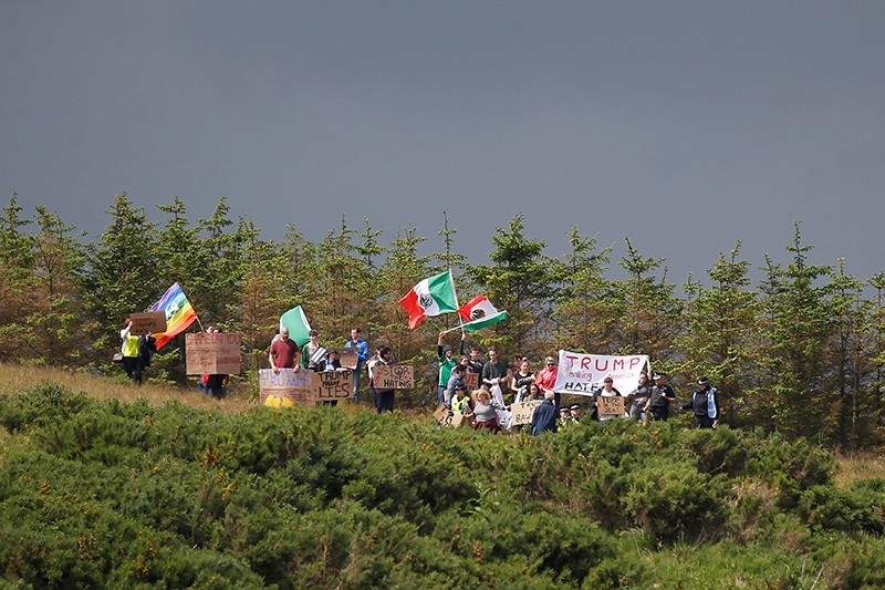 Protesters wave flags and signs on the road leading into Republican presidential candidate Donald Trump's Trump International Golf Links in Aberdeen, Scotland, June 25, 2016.  (Reuters Photo)