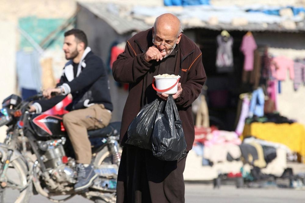 A man eats food that was distributed as aid in an opposition-held besieged area in Aleppo, Syria, Nov. 6.