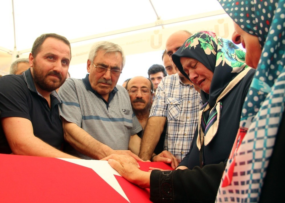 Cengiz Hasbalu2019s family mourn over his flag-draped coffin. (IHA Photo)