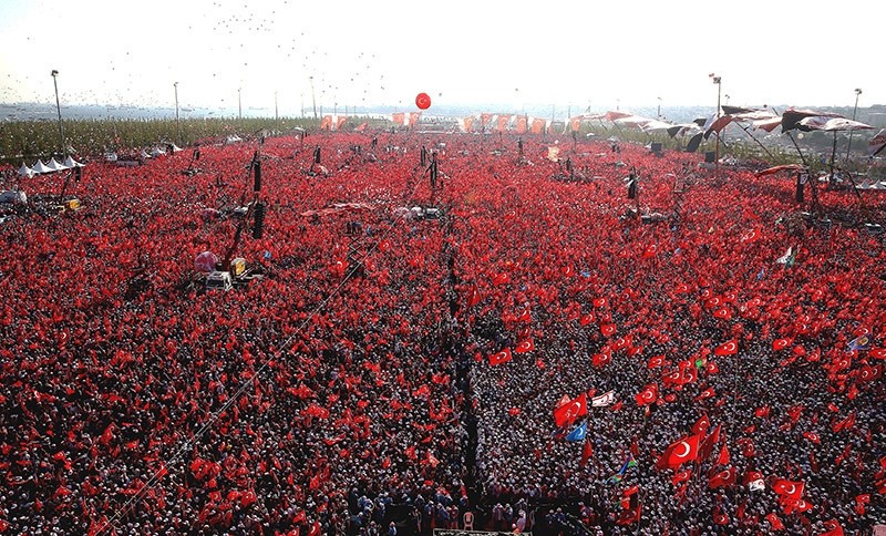 People wave Turkish flags and picture of Turkish President Recep Tayyip Erdou011fan during a rally to protest the failed coup attempt on 15 July 2016. (IHA Photo)