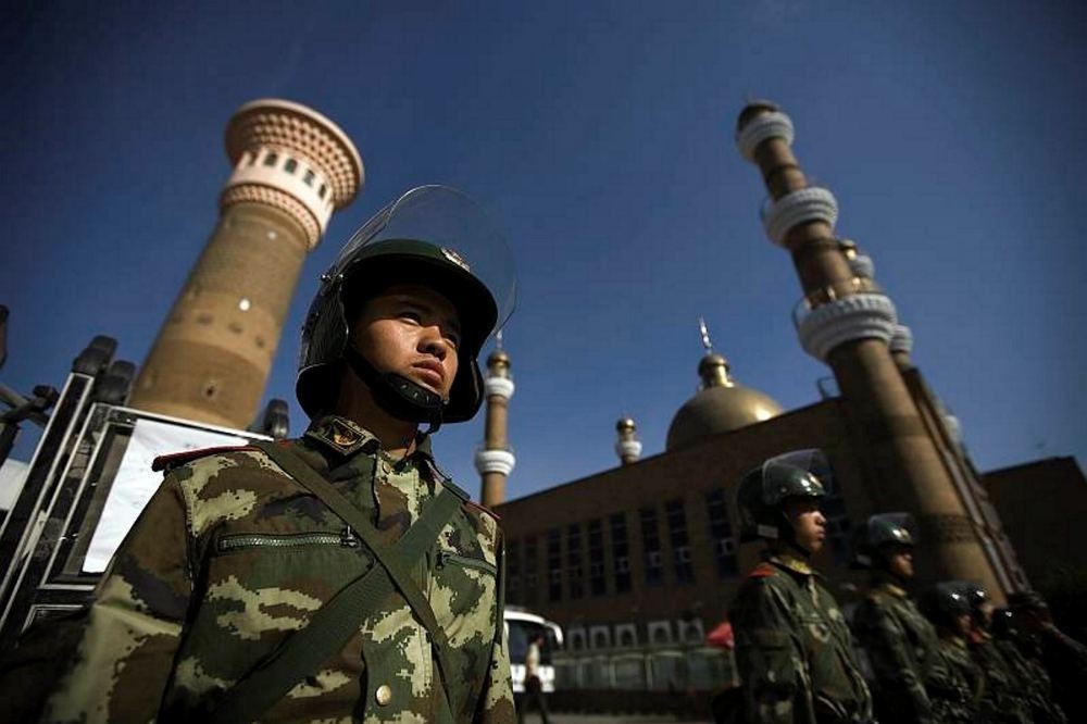 Chinese security forces patrol the entrance to a historic mosque in Xinjiang.