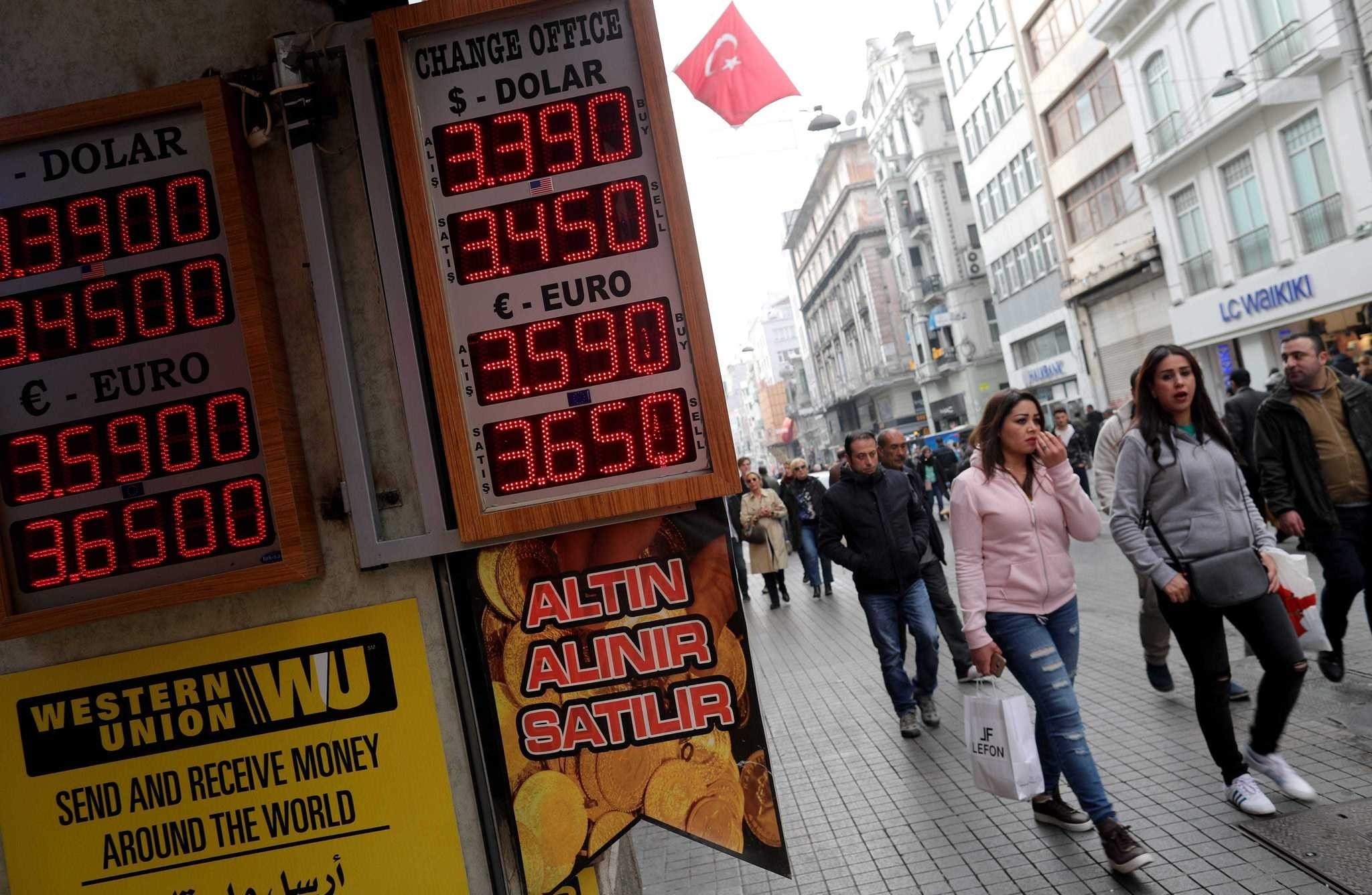 People walk near an exchange office on Istiklal Street in Istanbul. 